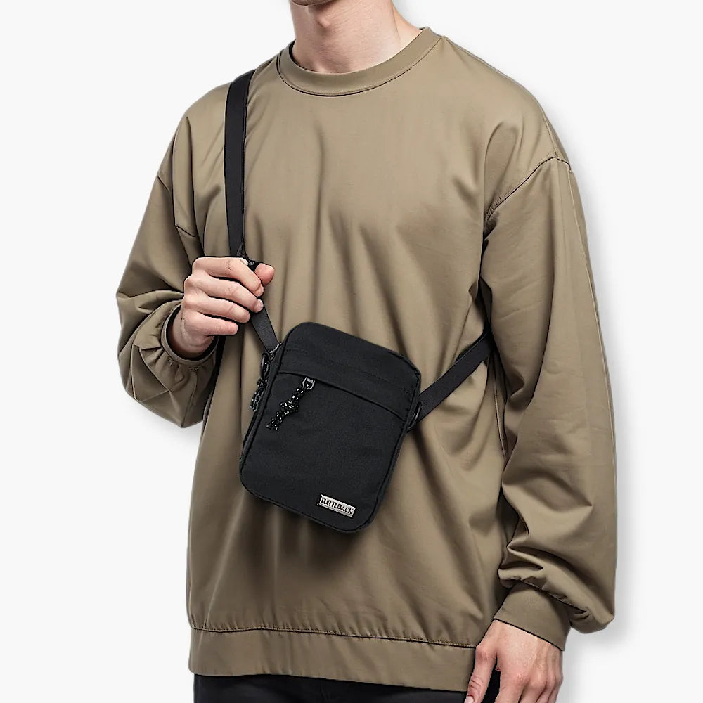 Mann in braunem Oberteil trägt schwarze Reporter Bag
