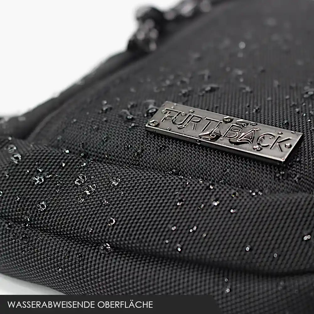 Nahaufnahme des Turtlback-Logos auf einer schwarzen mini Chest Bag mit Wassertropfen, die die wasserabweisende Eigenschaft der Tasche zeigen