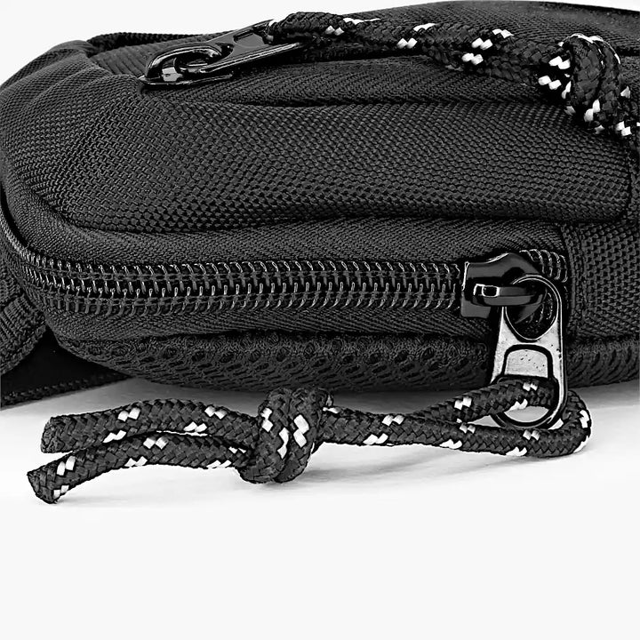 Nahaufnahme des unteren Bereichs einer schwarzen mini Sling Bag mit Reißverschluss und Kordel als Zipper-Verlängerung